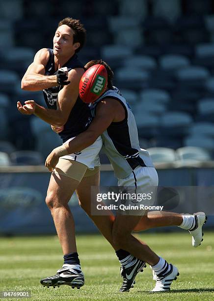 Harry Taylor of the Cats handballs whilst being tackled during a Geelong Cats Intra-Club Match at Skilled Stadium on February 13, 2009 in Melbourne,...