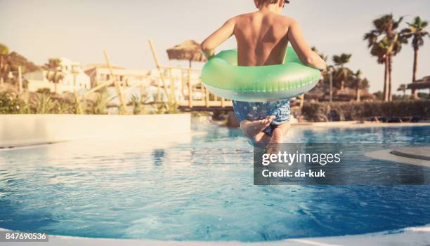 summer activities in the swimming pool - kid jumping into swimming pool stock pictures, royalty-free photos & images