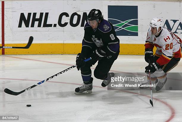 Drew Doughty of the Los Angeles Kings skates against Curtis Glencross of the Calgary Flames on February 12, 2009 at Staples Center in Los Angeles,...