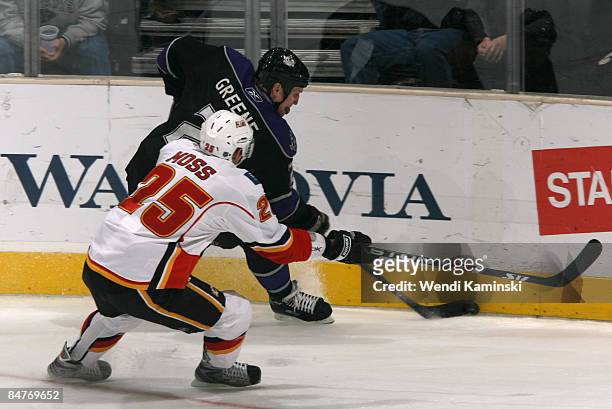 Matt Greene of the Los Angeles Kings handles the puck along the sideboards against David Moss of the Calgary Flames on February 12, 2009 at Staples...