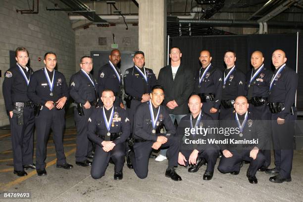 Wrestler and actor John Cena poses with the Los Angeles Police Department medal of valor winners before a game between the Calgary Flames and the Los...
