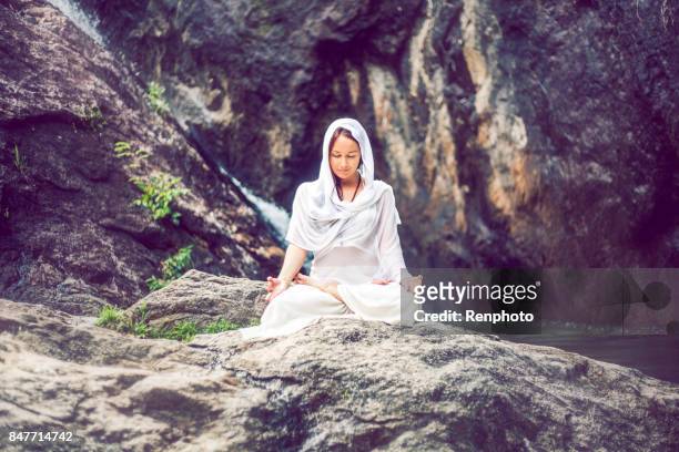beautiful woman meditating outside near waterfall - goddess stock pictures, royalty-free photos & images