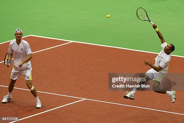 Jeff Coetzee of South Africa plays a smash with partner Wesley Moodie of South Africa looking on during their doubles quarterfinal match against...