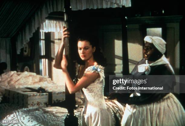Mammy, played by American actress Hattie McDaniel , tightens the corset of Scarlett O'Hara, played by English actress Vivien Leigh , in a scene from...