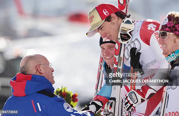 Switzerland's Carlo Janka is congratulated by French Secretary of State for Sports Bernard Laporte as Austrian Benjamin Raich and Ted Ligety of the...