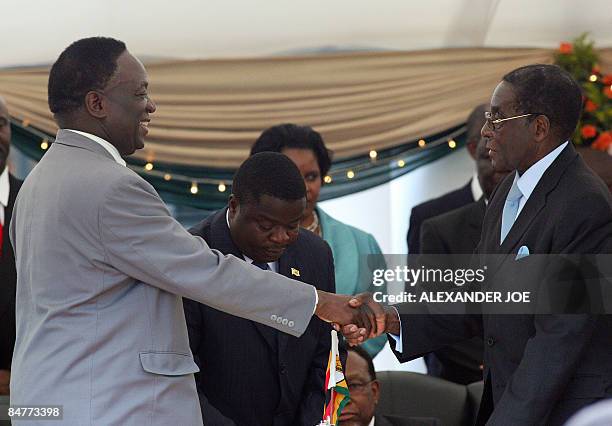 President Robert Mugabe congratulates his new Defence Minister Emmerson Mnangagwa at the State House in Harare on February 13, 2009. The defence...