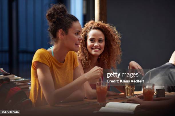 young women talking and laughing in courtyard of hostel - girls chatting cafe stock pictures, royalty-free photos & images