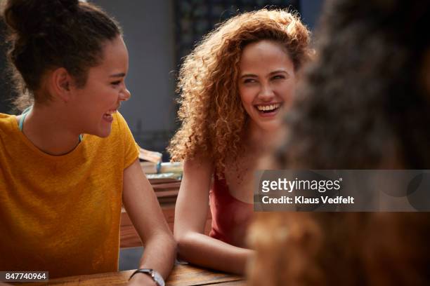 young women talking and laughing in courtyard of hostel - cerca de fotografías e imágenes de stock