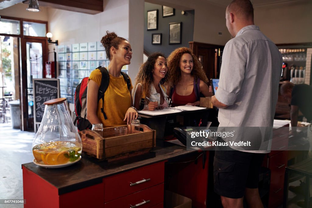 Young women signing in to youth hostel