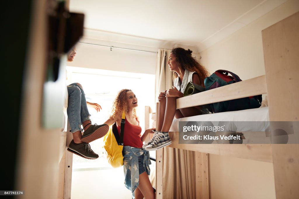 Young women arriving to room with bunk beds, at youth hostel