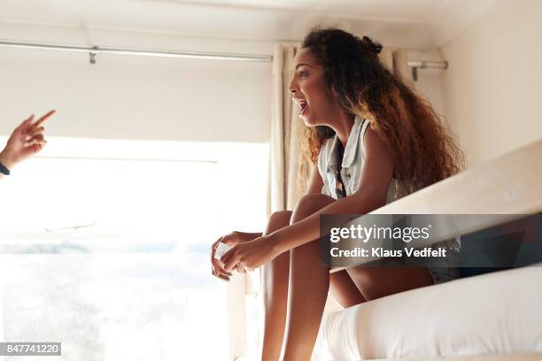 Young women sitting in bunk beds and talking and laughing together