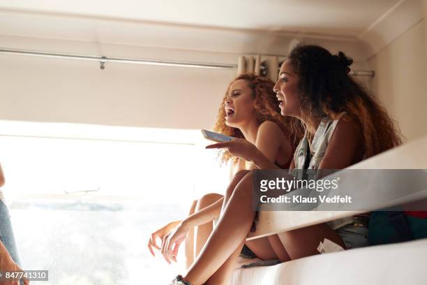 young women sitting in bunk beds and talking and laughing together - summer university day 2 foto e immagini stock