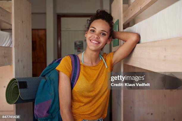 portrait of young smiling woman at youth hostel - yoga pose photos et images de collection