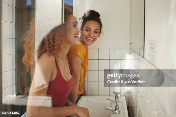 friends getting ready in front of mirror in bathroom - beautiful college girls stock-fotos und bilder