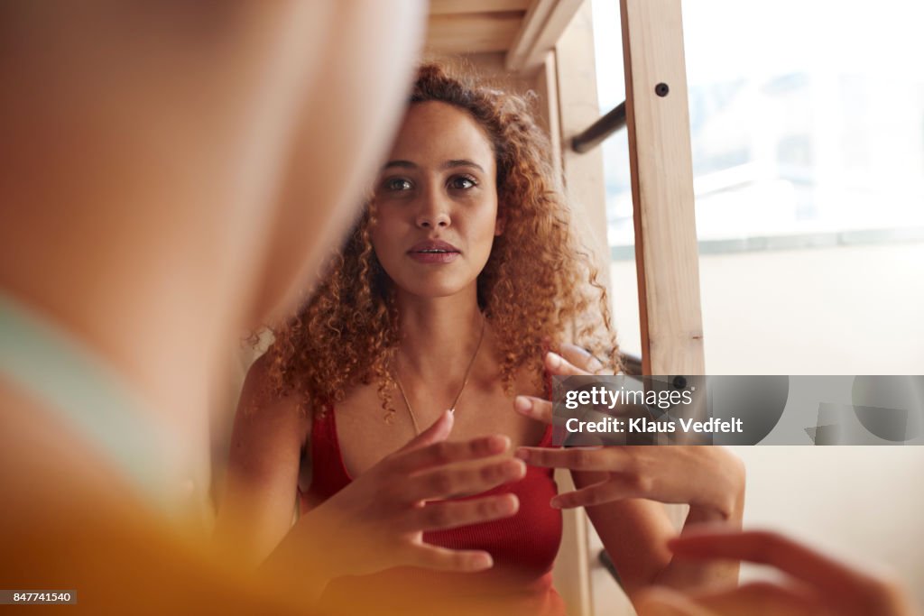 Close-up young women talking, while sitting in bunk bed