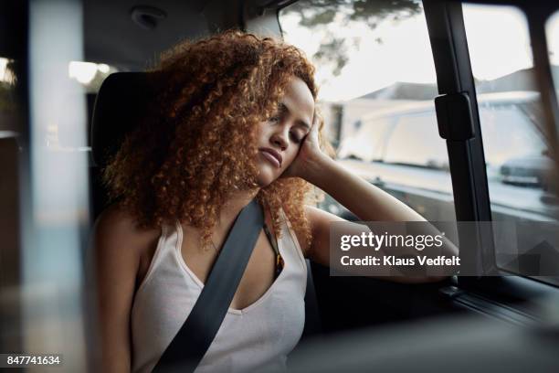 young woman sleeping on backseat of car - sicherheitsgurt stock-fotos und bilder