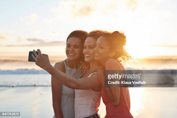 young women making selfie on the beach - young woman beach stockfoto's en -beelden