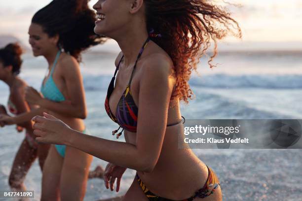 three young women running in the water, at the beach - ado en maillot de bain photos et images de collection