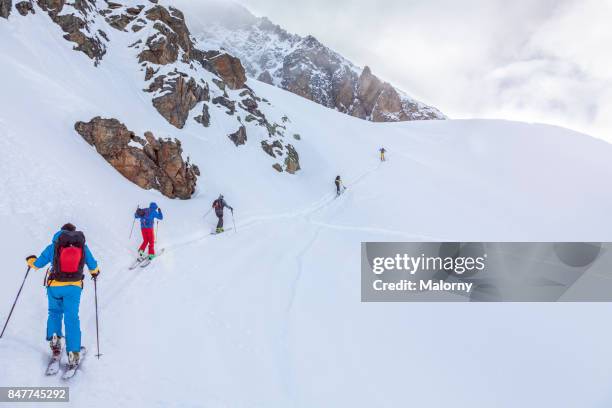 group of people skiing in deep snow - ski tour, backcountry ski - telemark fotografías e imágenes de stock