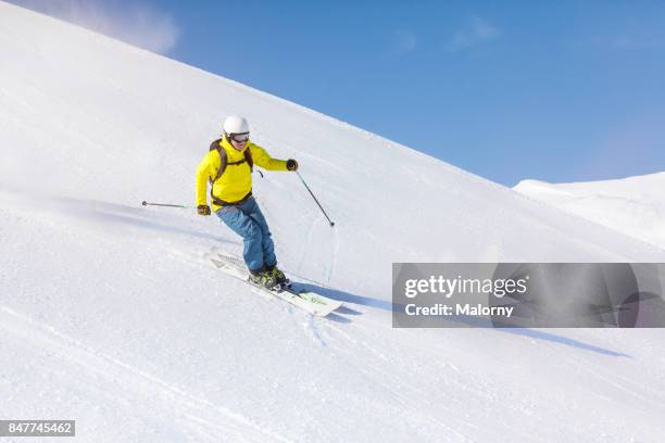 young man back country skiing in deep snow, powder snow. - downhill skiing stock pictures, royalty-free photos & images