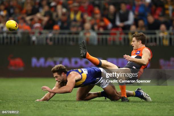 Heath Shaw of the Giants kicks over Mark Hutchings of the Eagles during the AFL First Semi Final match between the Greater Western Sydney Giants and...