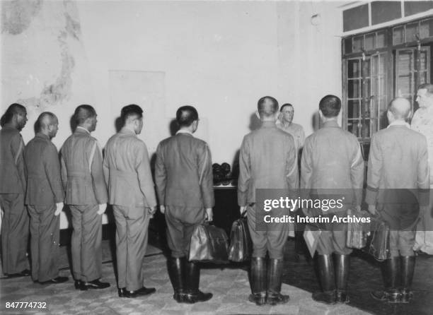 Member of the Japanese delegation presents their credentials to American Lieutenant General Richard K Sutherland at General MacArthur's headquarters...