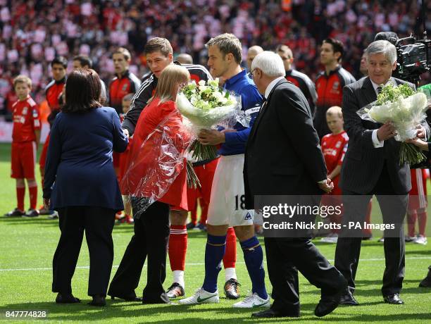 Everton's captain Phil Neville , Liverpool's captain Steven Gerrard and FA Chairman David Bernstein hand flowers to representatives of the...