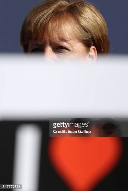 German Chancellor and Chrstian Democrat Angela Merkel looks out from behind a supporter's placard after she spoke at an election campaign stop on the...