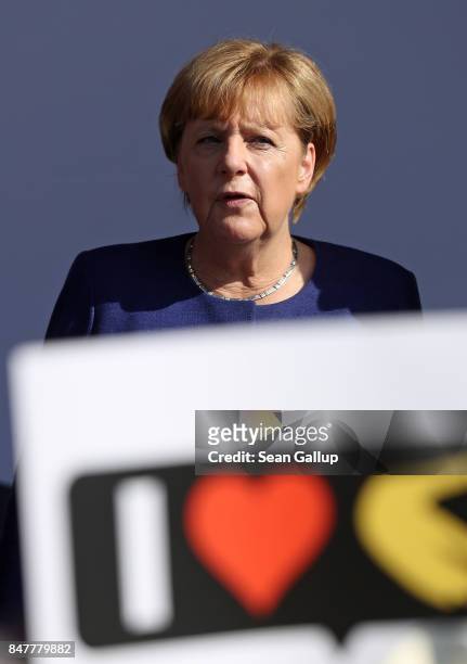German Chancellor and Chrstian Democrat Angela Merkel looks out from behind a supporter's placard after she spoke at an election campaign stop on the...