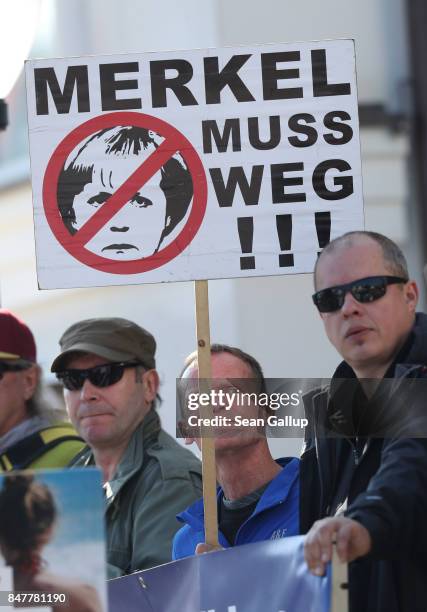 Protester holds a sign that read: "Merkel must go!" on the edge of an election campaign stop of German Chancellor and Chrstian Democrat Angela Merkel...