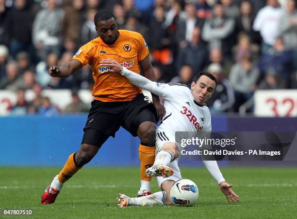 Wolves Sylvan Ebanks-Blake is tackled by Swansea's Leon Britton during the Barclays Premier League match at the Liberty Stadium, Swansea.