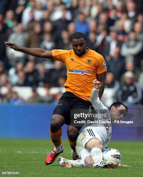 Wolves' Sylvan Ebanks-Blake is tackled by Swansea's Leon Britton during the Barclays Premier League match at the Liberty Stadium, Swansea.