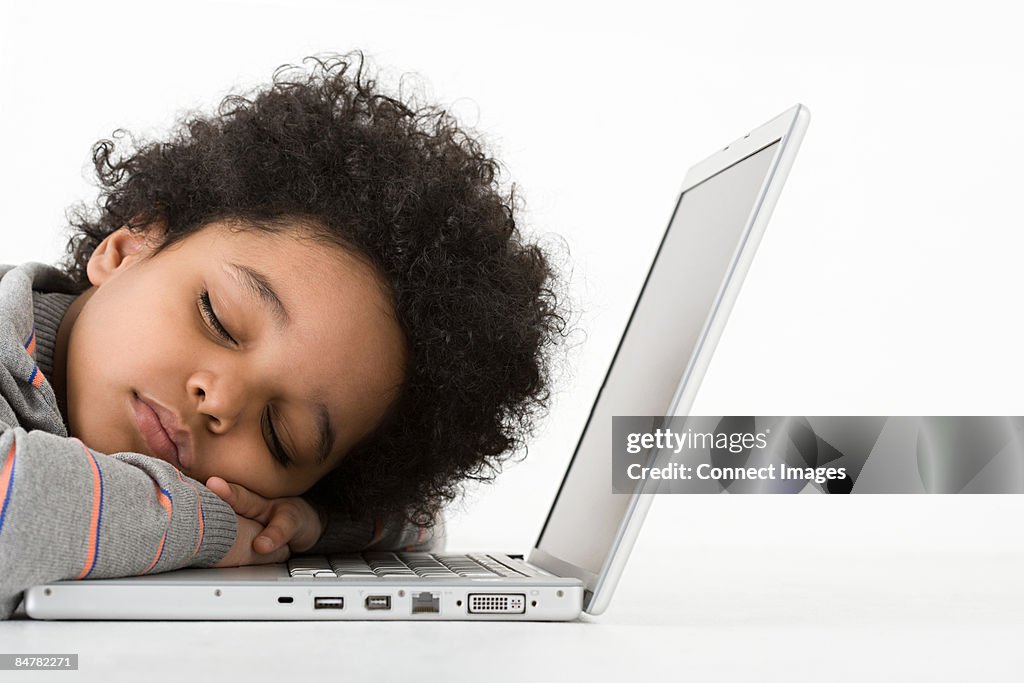 Boy asleep on laptop