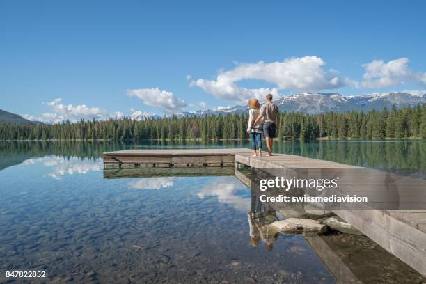 young couple relaxing on lake pier - jasper stock pictures, royalty-free photos & images