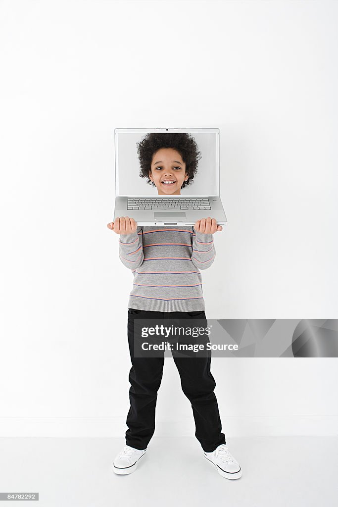 Boy with face on laptop