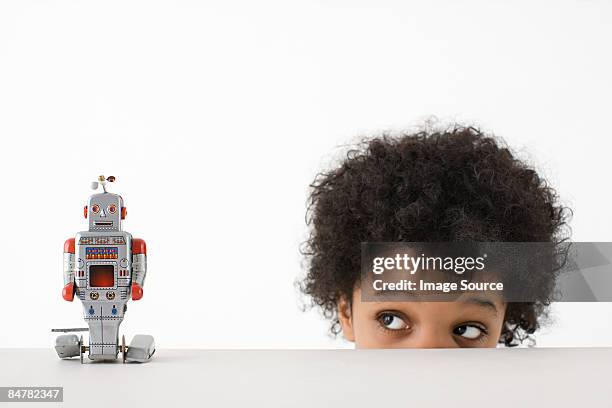 boy looking at robot - child with robot stockfoto's en -beelden