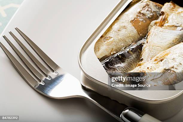 a can of sardines and a fork - sardine can fotografías e imágenes de stock