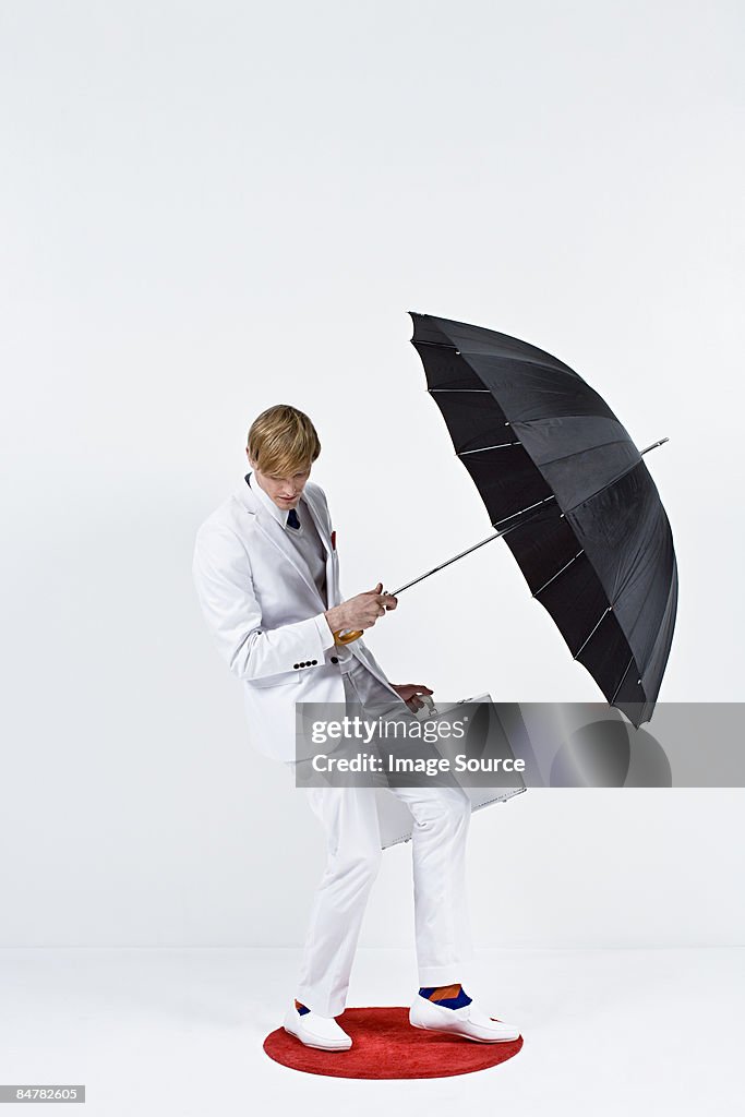 A businessman holding an umbrella