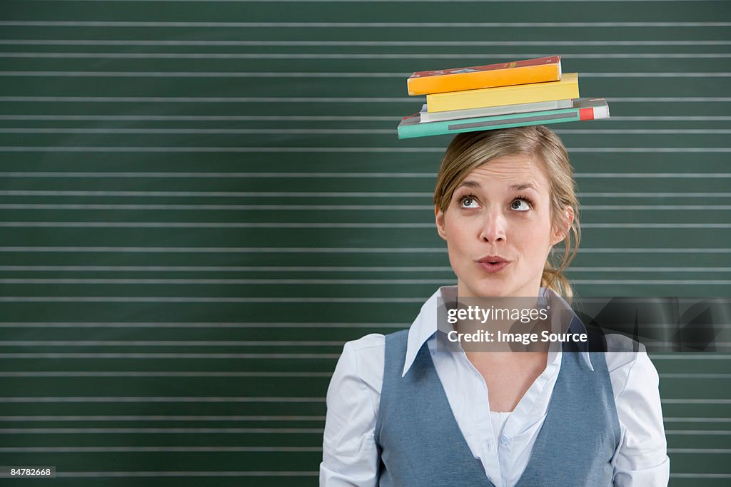 Teacher with books on her head