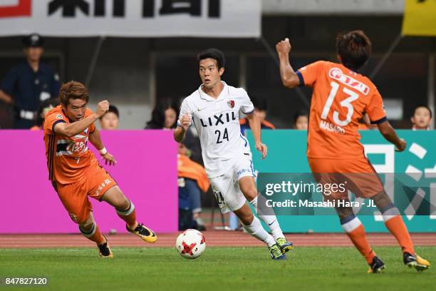 Yukitoshi Ito of Kashima Antlers controls the ball under pressure of Ryohei Yamazaki and Masaru Kato of Albirex Niigata during the J.League J1 match...