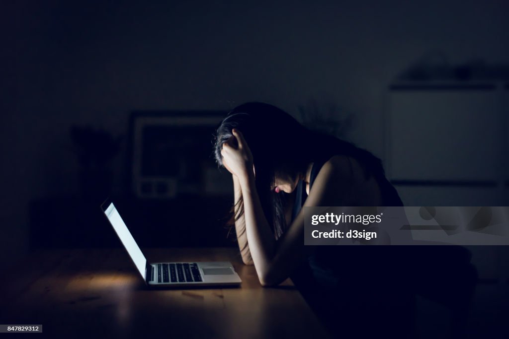 Stressed and frustrated businesswoman working till late at work