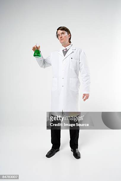 scientist holding flask - laboratoriumjas stockfoto's en -beelden
