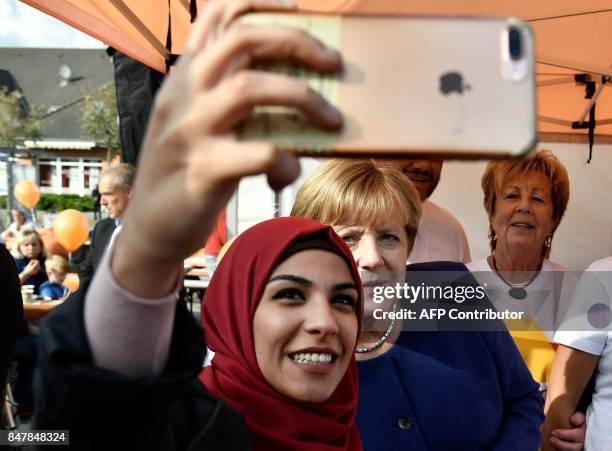 Syrian refugee poses for a selfie photo with German Chancellor Angela Merkel as she continued on the election campaign trail in Stralsund on...