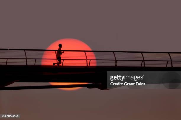 man out for morning run over bridge. - morning stock pictures, royalty-free photos & images