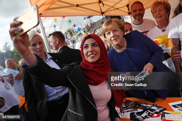 German Chancellor and Chrstian Democrat Angela Merkel poses for a selfie with a young woman who came one year ago from Iran during a brief visit by...