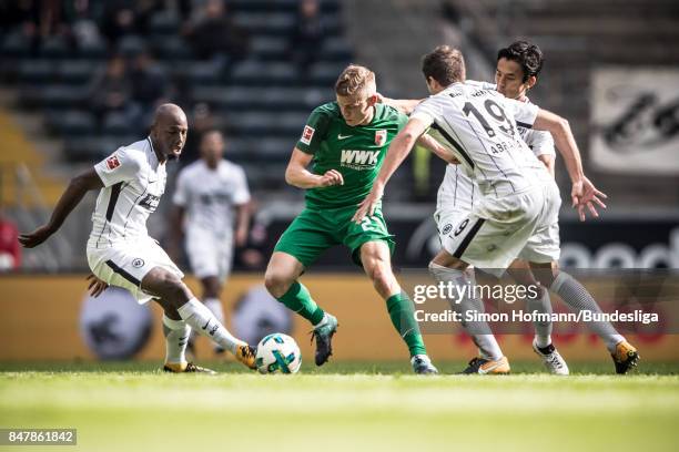 Alfred Finnbogason of Augsburg is tackled by Makoto Hasebe, David Abraham and Jetro Williams of Frankfurt during the Bundesliga match between...