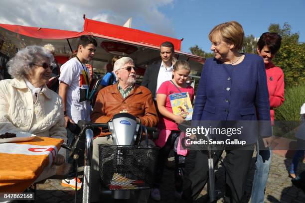 German Chancellor and Chrstian Democrat Angela Merkel greets elderly visitors during a brief visit by Merkel to a local CDU-organized fest on...