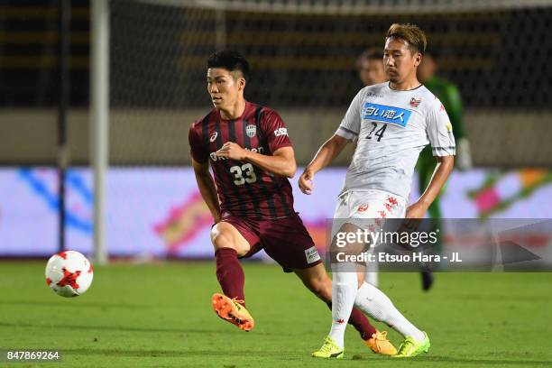 Akito Fukumori of Consadole Sapporo controls the ball under pressure of Shuhei Otsuki of Vissel Kobe during the J.League J1 match between Vissel Kobe...