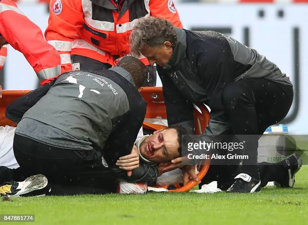 Christian Gentner of Stuttgart is being treated after a heavy foul on him by Koen Casteels of Wolfsburg during the Bundesliga match between VfB...
