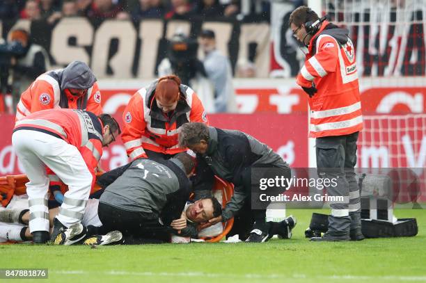 Christian Gentner of Stuttgart is being treated after a heavy foul on him by Koen Casteels of Wolfsburg during the Bundesliga match between VfB...